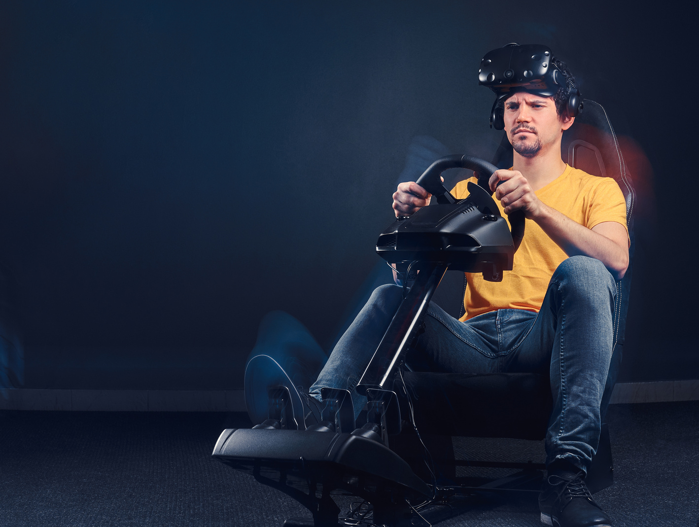 Man Wearing VR Headset Driving on Car Racing Simulator Cockpit with Seat and Wheel.